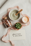 Self-care kit flat lay with bath salts, face mask, candle, and succulent on fluffy towel
